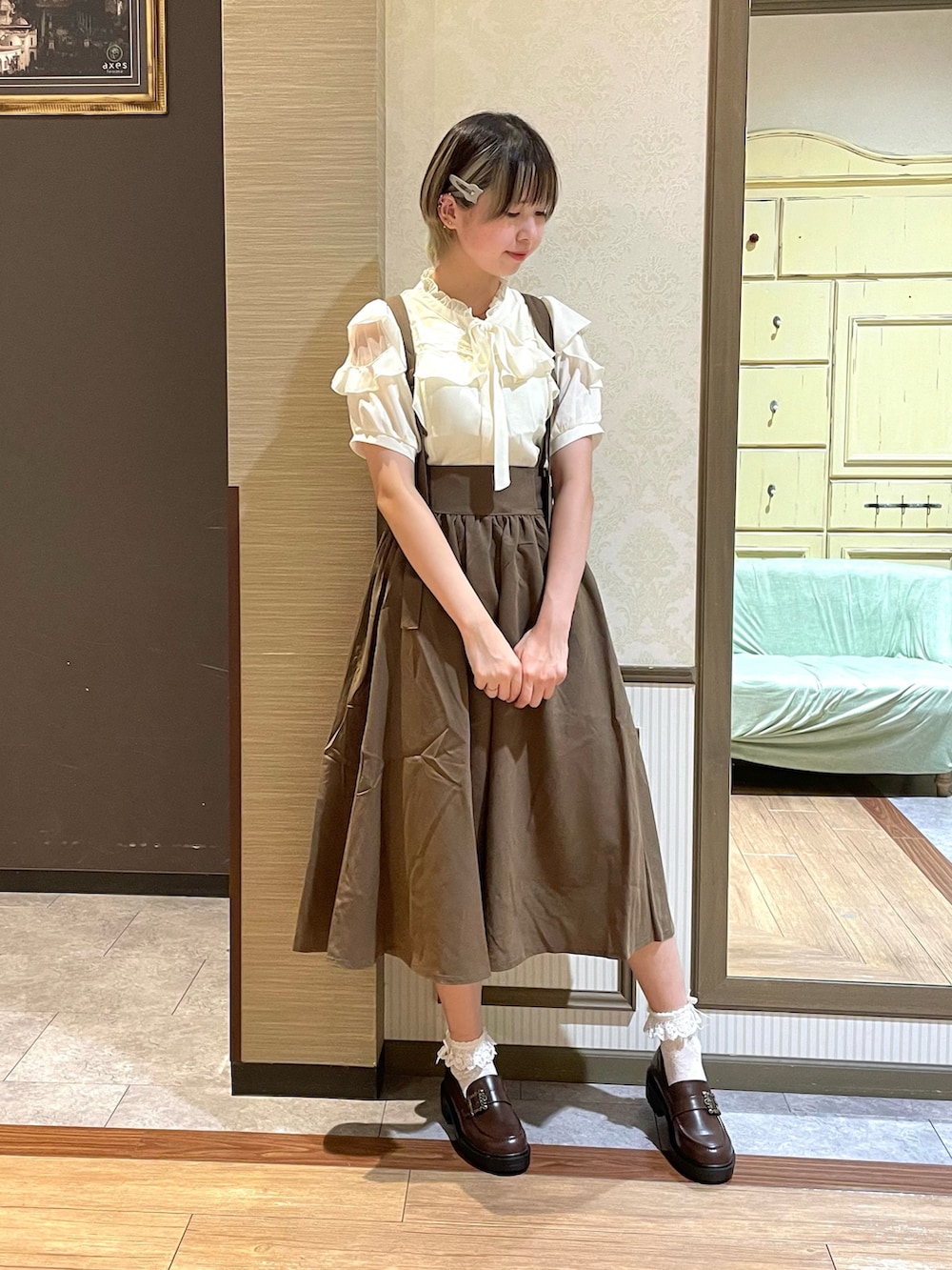 ブラウン系のパンプス、ホワイト系のショルダーバッグ、ブラウン系のスカートを着用したレディースの夏コーディネートの2枚目の写真