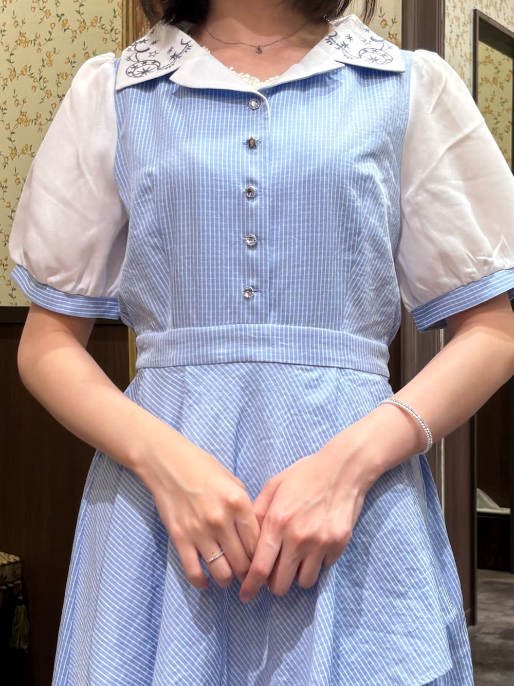 ホワイト系のタンクトップ、ブルー系のワンピース、ブラウン系のボストンバッグを着用したレディースの夏コーディネートの9枚目の写真