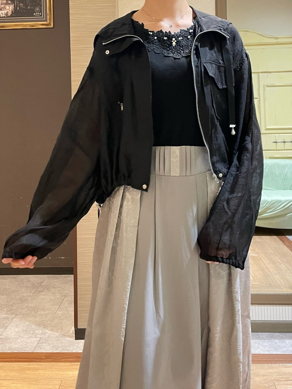 ブラック系のタンクトップ、ブラック系のブルゾン、ホワイト系のショルダーバッグを着用したレディースの秋コーディネートの4枚目の写真