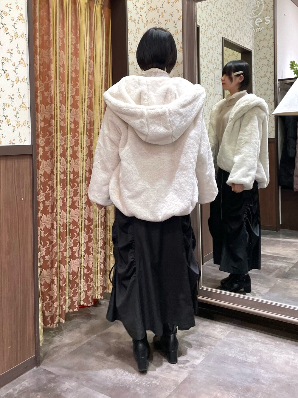 ピンク系のニット/セーター、ブラック系のスカート、ホワイト系のダッフルコートを着用したレディースの冬コーディネートの7枚目の写真