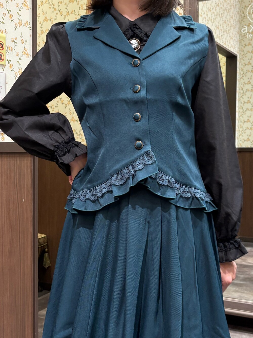 ブラック系のシャツ/ブラウス、ブルー系のベスト、ブルー系のスカートを着用したレディースの夏コーディネートの7枚目の写真