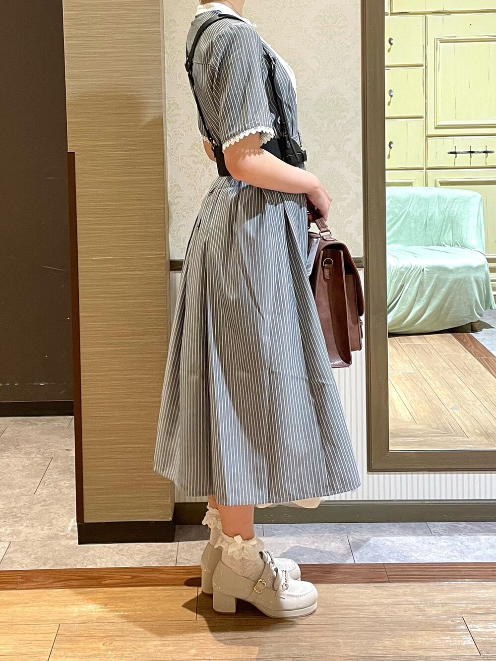 ホワイト系のタンクトップ、ホワイト系のローファー、ブラウン系のショルダーバッグを着用したレディースの夏コーディネートの3枚目の写真