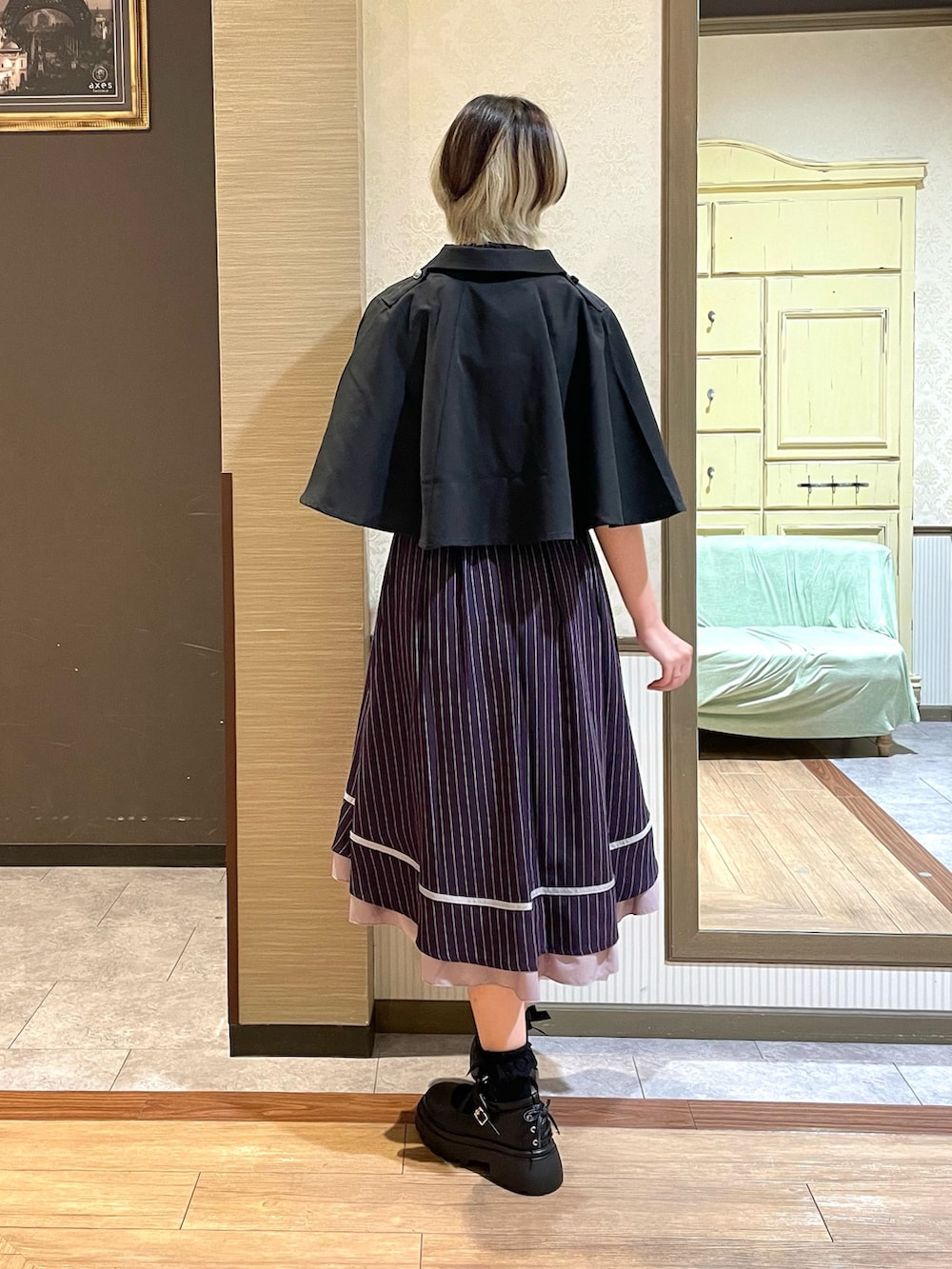 ホワイト系のタンクトップ、ブラック系のパンプス、ブラック系のボストンバッグを着用したレディースの夏コーディネートの3枚目の写真