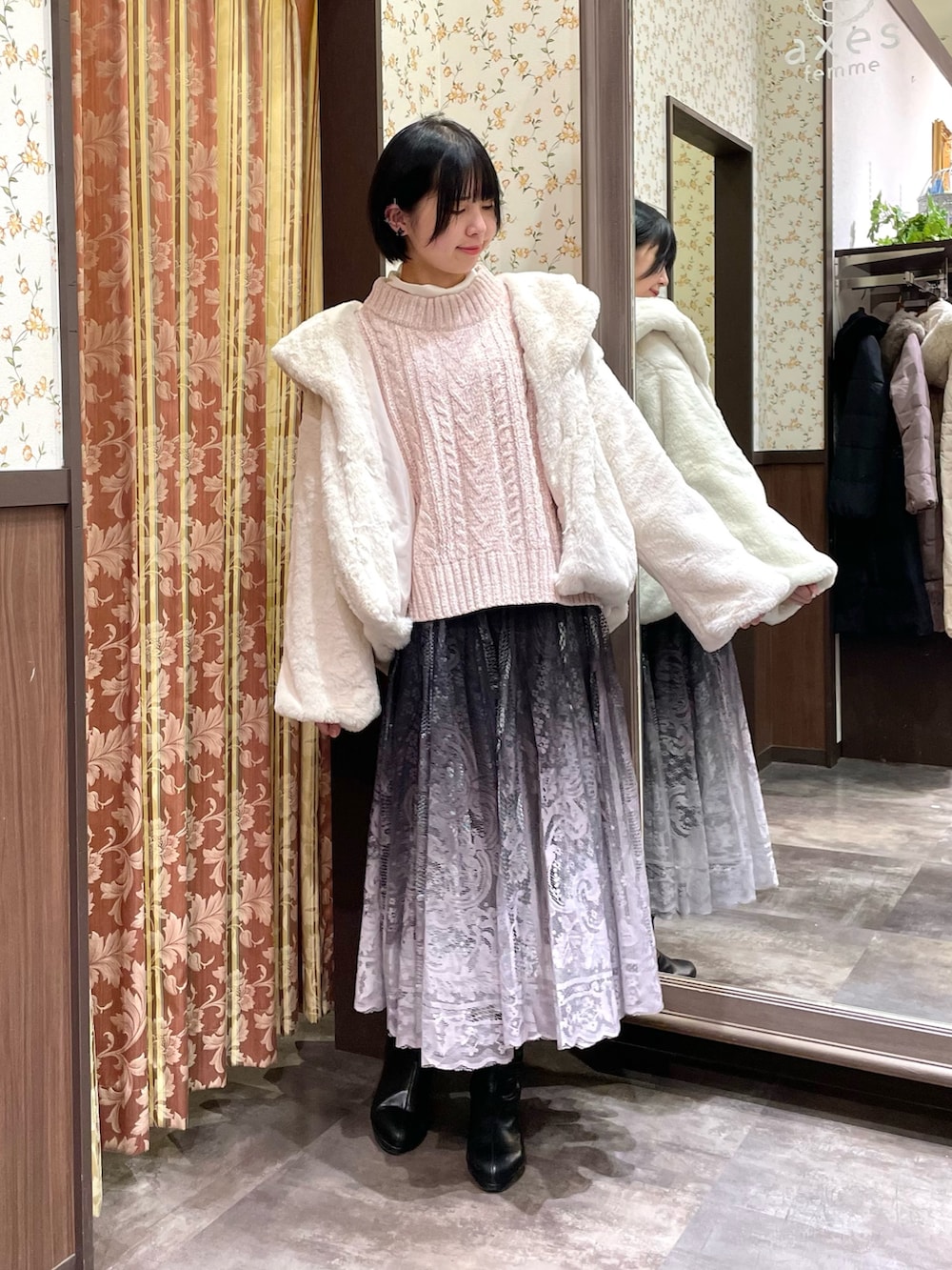 ホワイト系のダッフルコート、ピンク系のニット/セーター、ブラウン系のスカートを着用したレディースの冬コーディネートの3枚目の写真