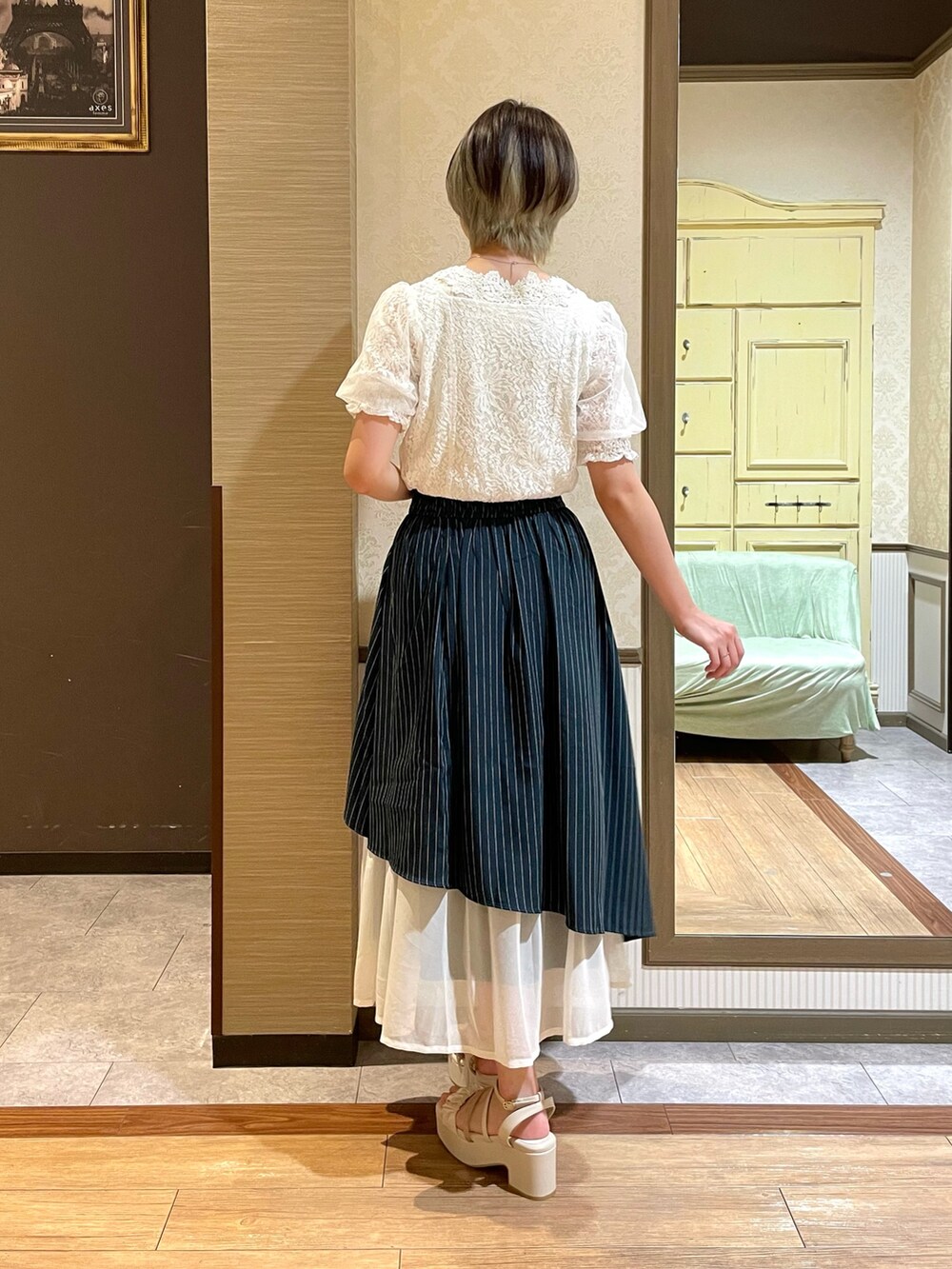 ホワイト系のサンダル、ベージュ系のショルダーバッグ、ホワイト系のタンクトップを着用したレディースの夏コーディネートの5枚目の写真