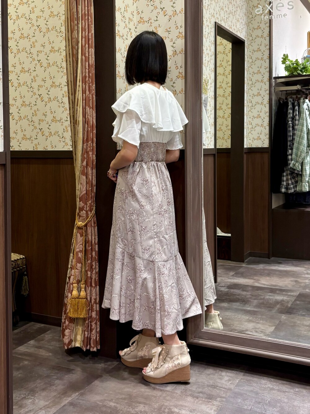 ベージュ系のワンピース、ホワイト系のタンクトップ、ベージュ系のショルダーバッグを着用したレディースの夏コーディネートの5枚目の写真