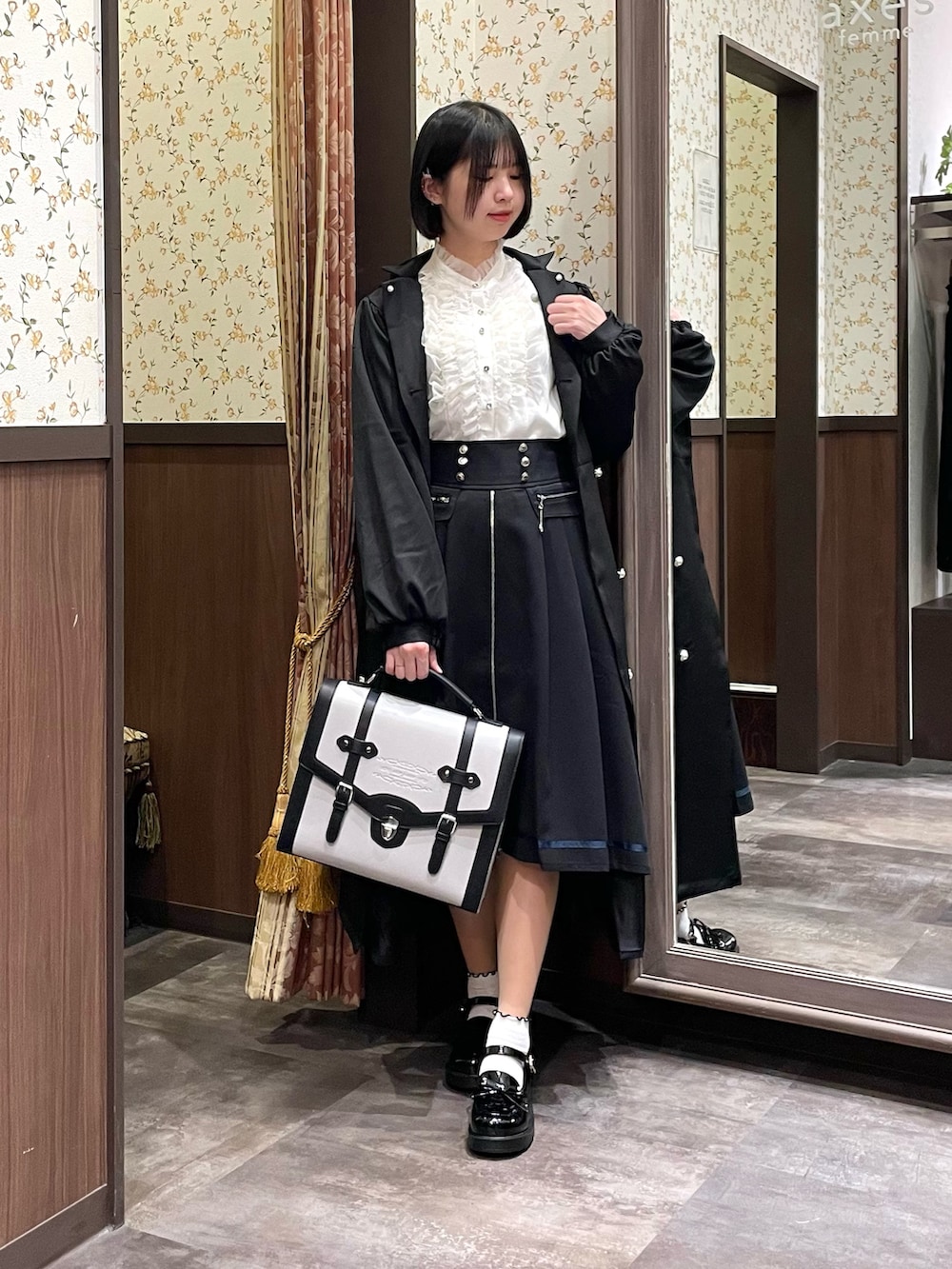 ホワイト系のシャツ/ブラウス、ブラック系のローファー、ブラック系のトレンチコートを着用したレディースの春コーディネートの6枚目の写真