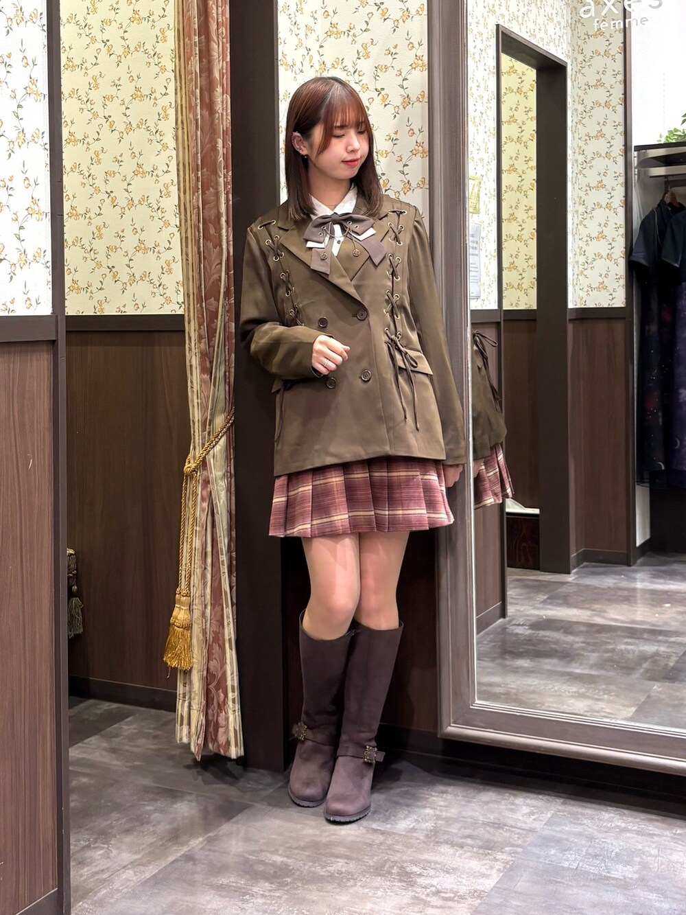 レッド系のベスト、ピンク系のその他パンツ、ブラウン系のブーツを着用したレディースの秋コーディネートの6枚目の写真