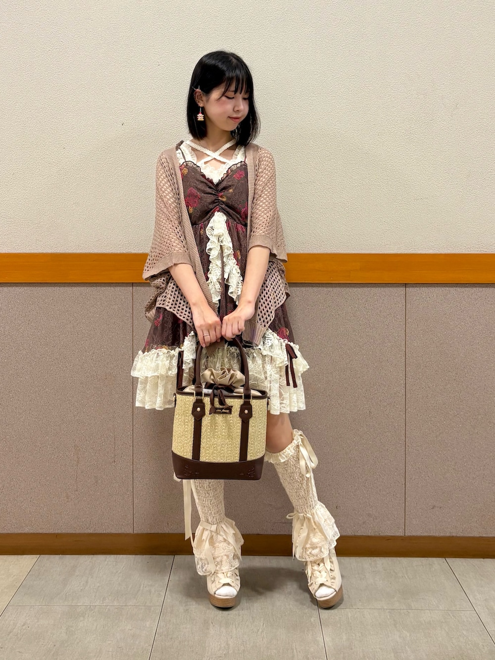 ホワイト系のタンクトップ、ブラウン系のカーディガン/ボレロ、ブラウン系のチュニックを着用したレディースの夏コーディネートの2枚目の写真