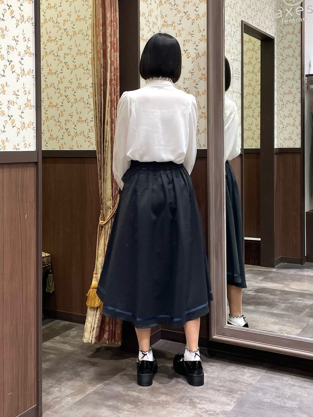 ホワイト系のシャツ/ブラウス、ブラック系のローファー、ブラック系のトレンチコートを着用したレディースの春コーディネートの4枚目の写真