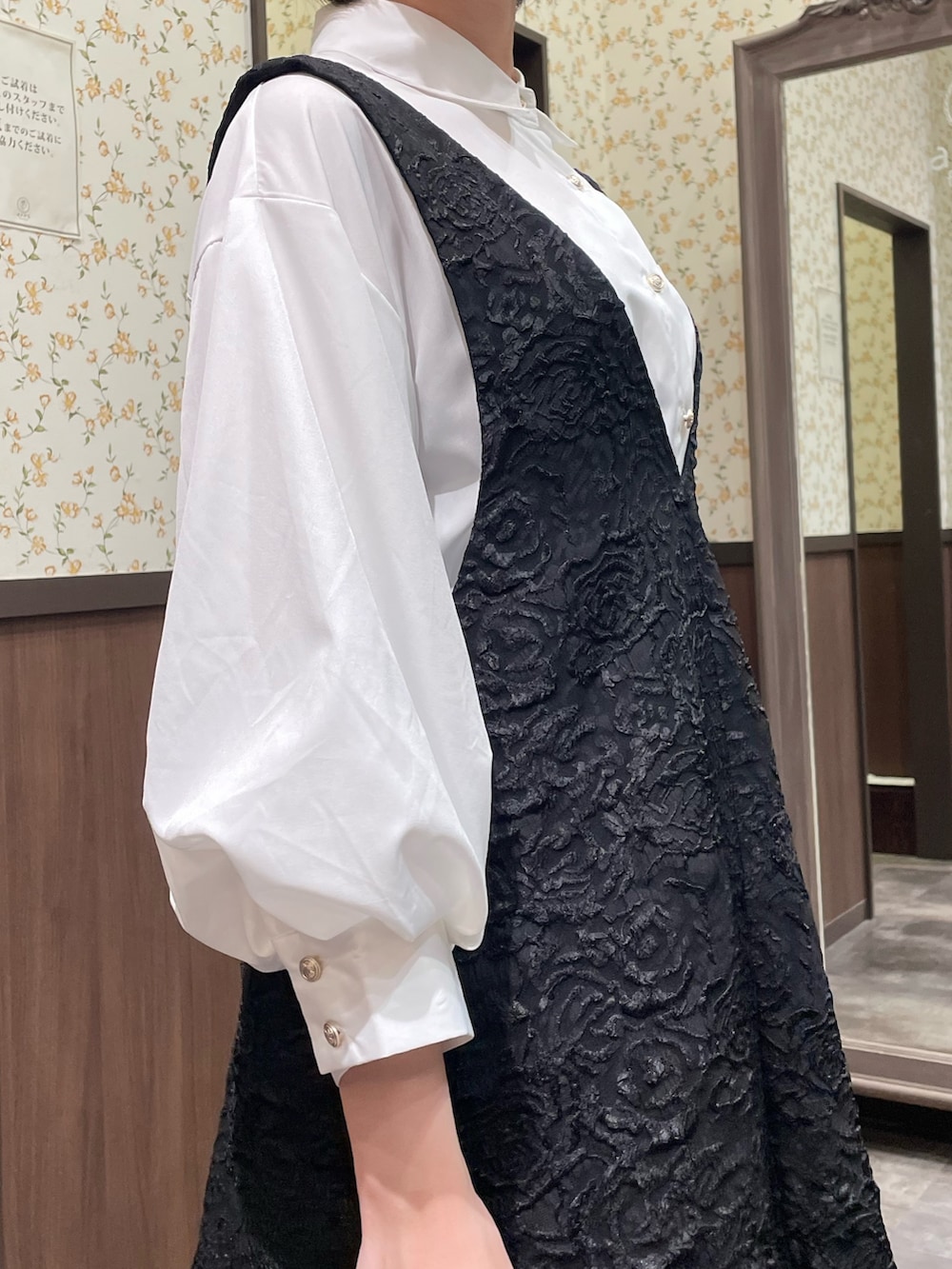 ホワイト系のシャツ/ブラウス、ブラック系のジャンパースカート、ブラック系のブーツを着用したレディースの春コーディネートの8枚目の写真