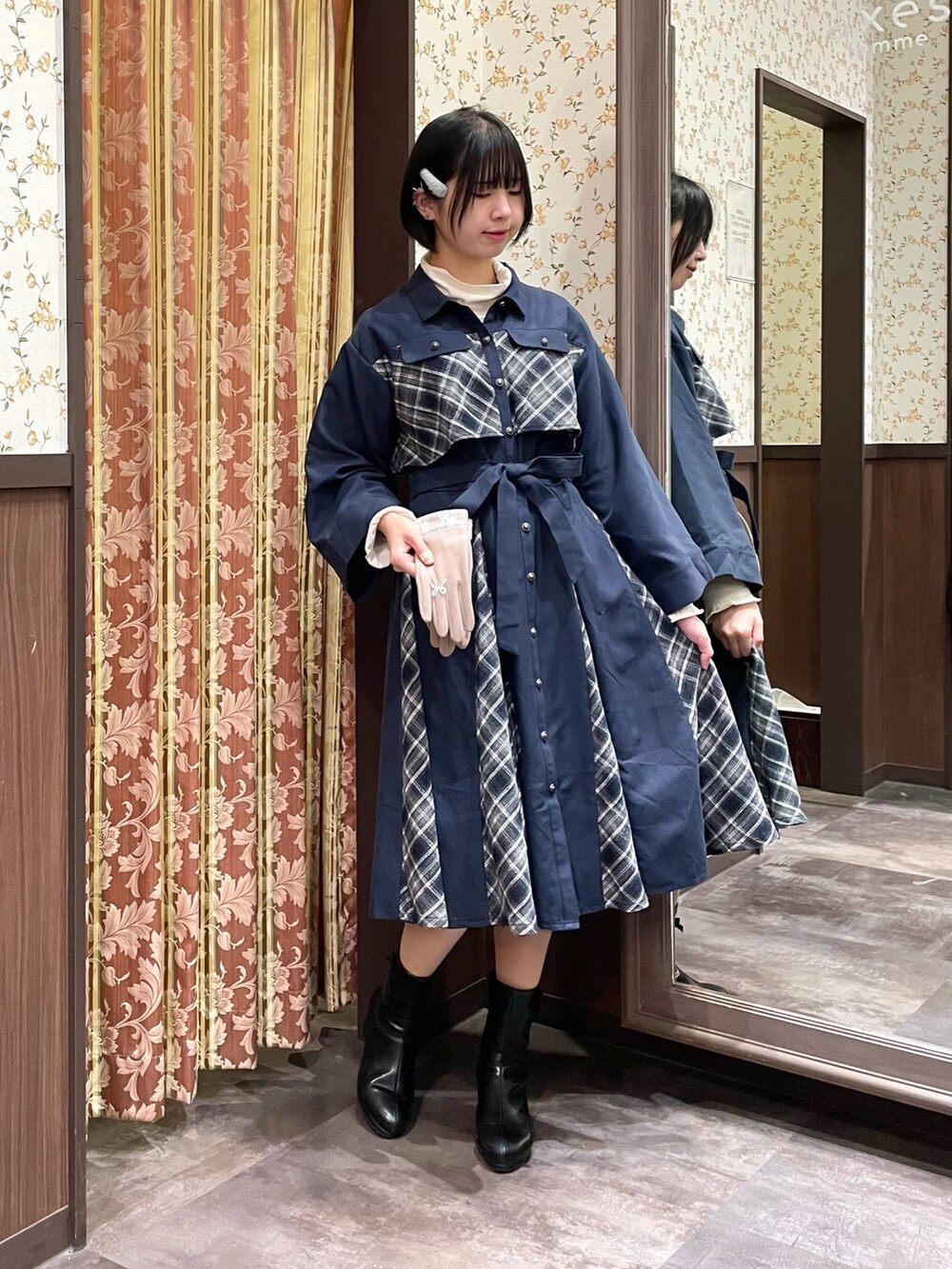 ホワイト系のピーコート、ブルー系のワンピース、ブラック系のブーツを着用したレディースの冬コーディネートの4枚目の写真