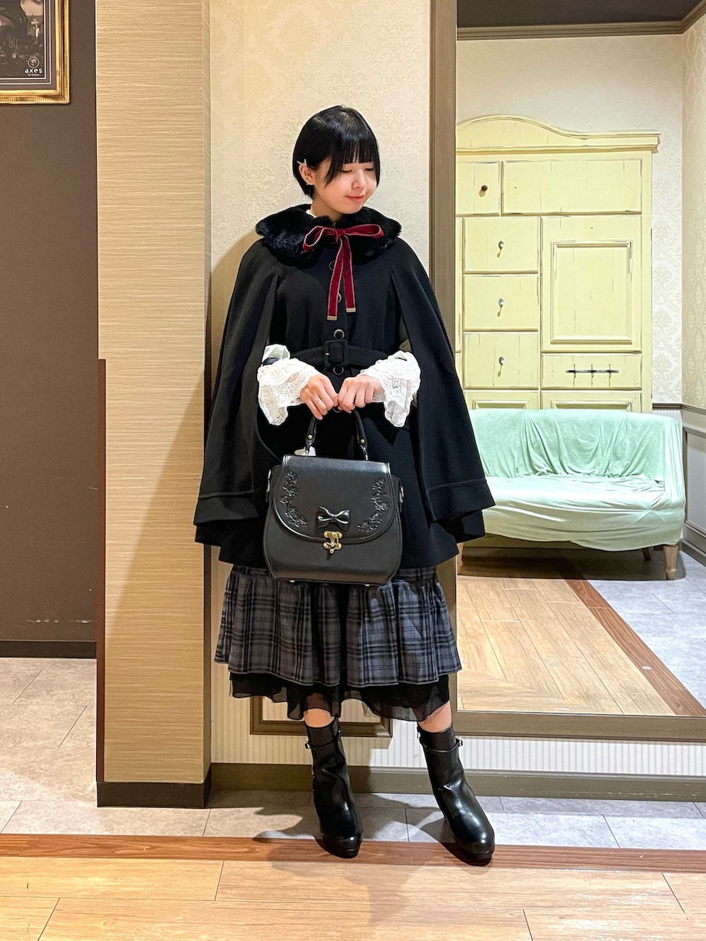 ブルー系のスカート、ブラック系のブーツ、ホワイト系のシャツ/ブラウスを着用したレディースの秋コーディネートの2枚目の写真