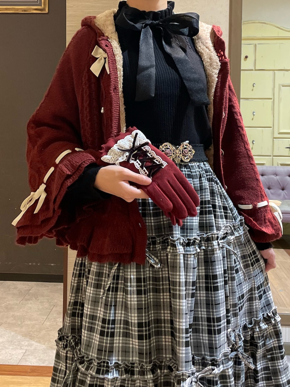 ブラック系のニット/セーター、レッド系のポンチョ、ブラック系のトートバッグを着用したレディースの秋コーディネートの3枚目の写真