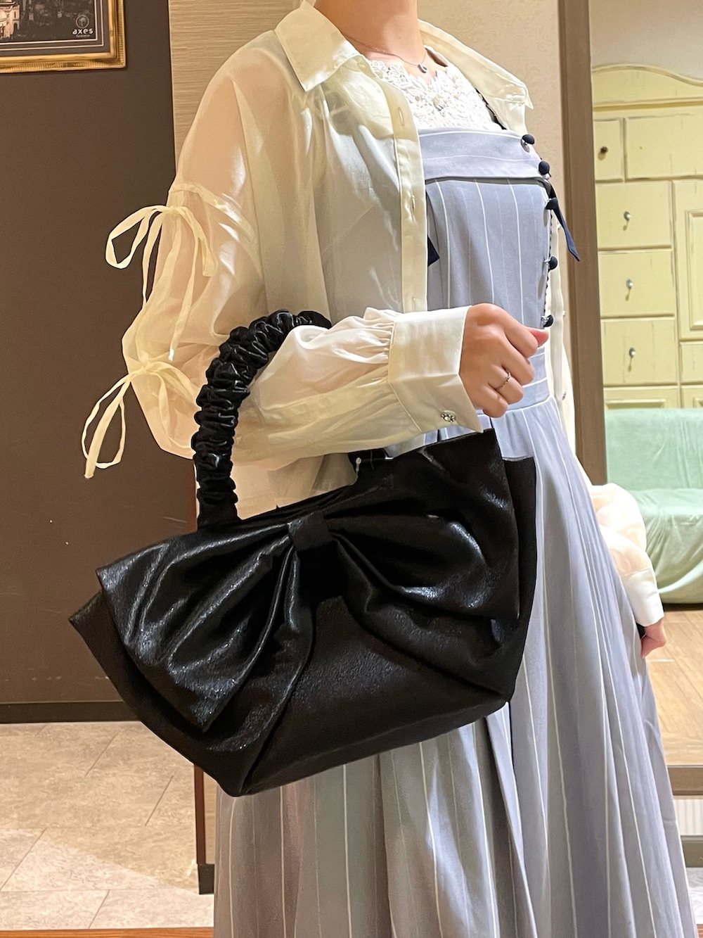 ブラック系のブーツ、ホワイト系のシャツ/ブラウス、ホワイト系のタンクトップを着用したレディースの夏コーディネートの2枚目の写真