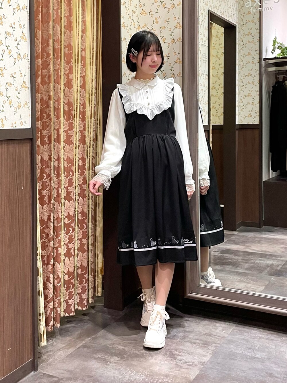 ホワイト系のスニーカー、ブラック系のワンピース、ブラック系のショルダーバッグを着用したレディースの春コーディネートの7枚目の写真