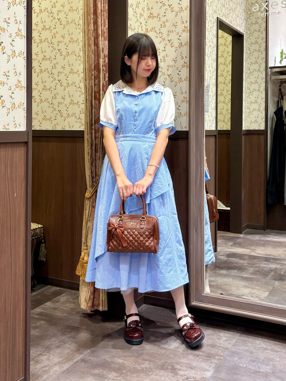 ホワイト系のタンクトップ、ブルー系のワンピース、ブラウン系のボストンバッグを着用したレディースの夏コーディネートの2枚目の写真