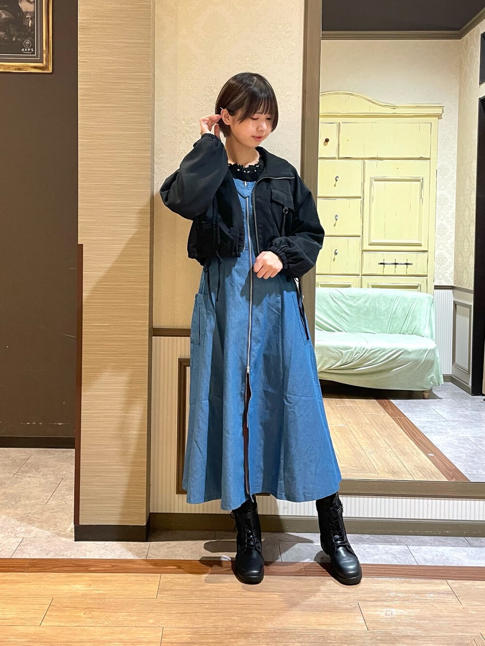 ブルー系のジャンパースカート、ブラック系のブーツを着用したレディースの秋コーディネートの4枚目の写真