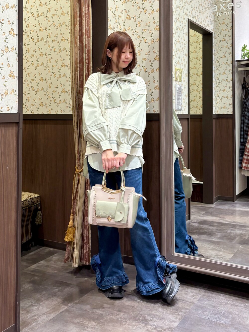 グリーン系のシャツ/ブラウス、ホワイト系のベスト、グリーン系のボストンバッグを着用したレディースの冬コーディネートの2枚目の写真