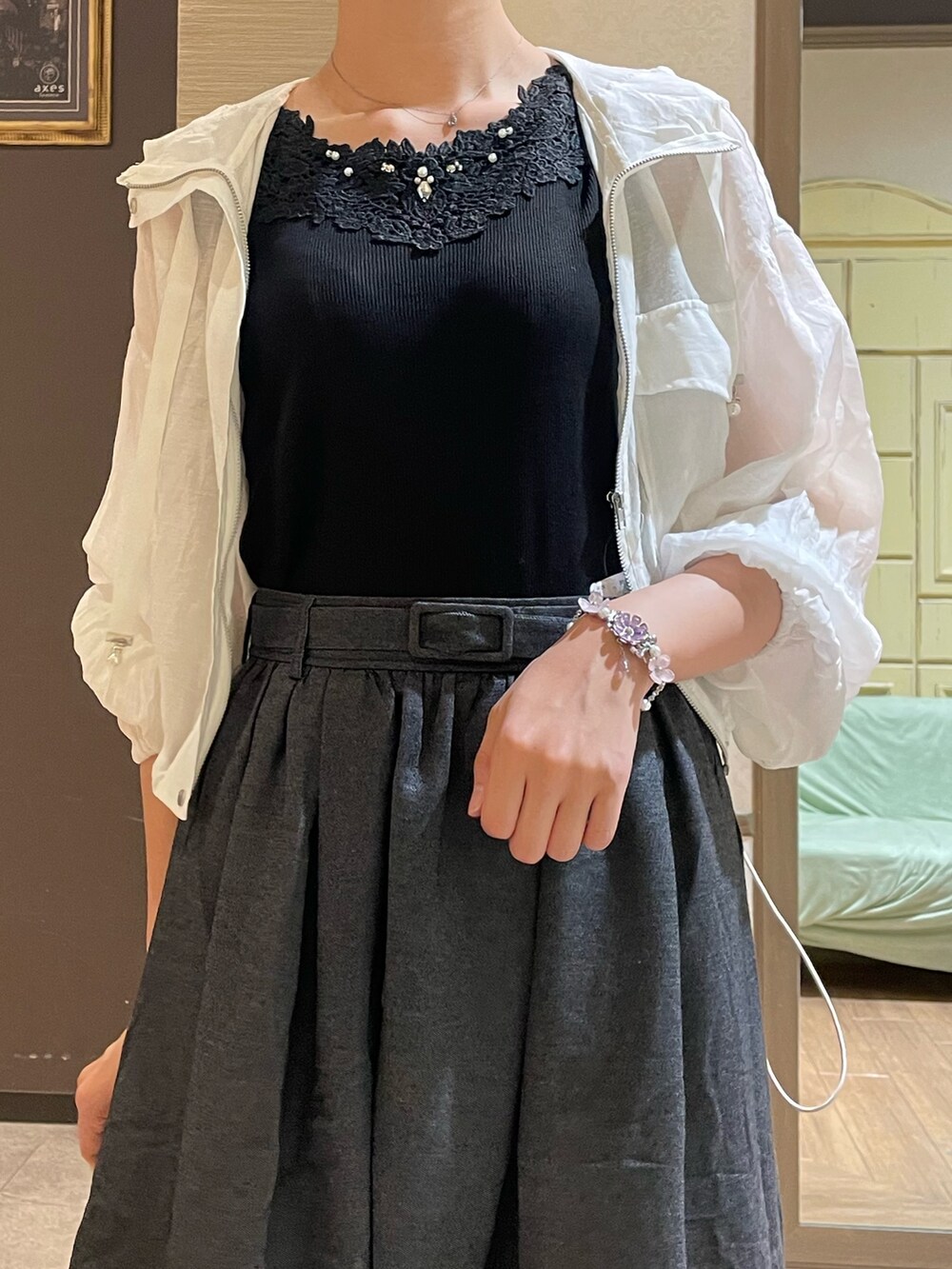 ホワイト系のブルゾン、ブラック系のタンクトップ、ブラック系のスカートを着用したレディースの秋コーディネートの2枚目の写真