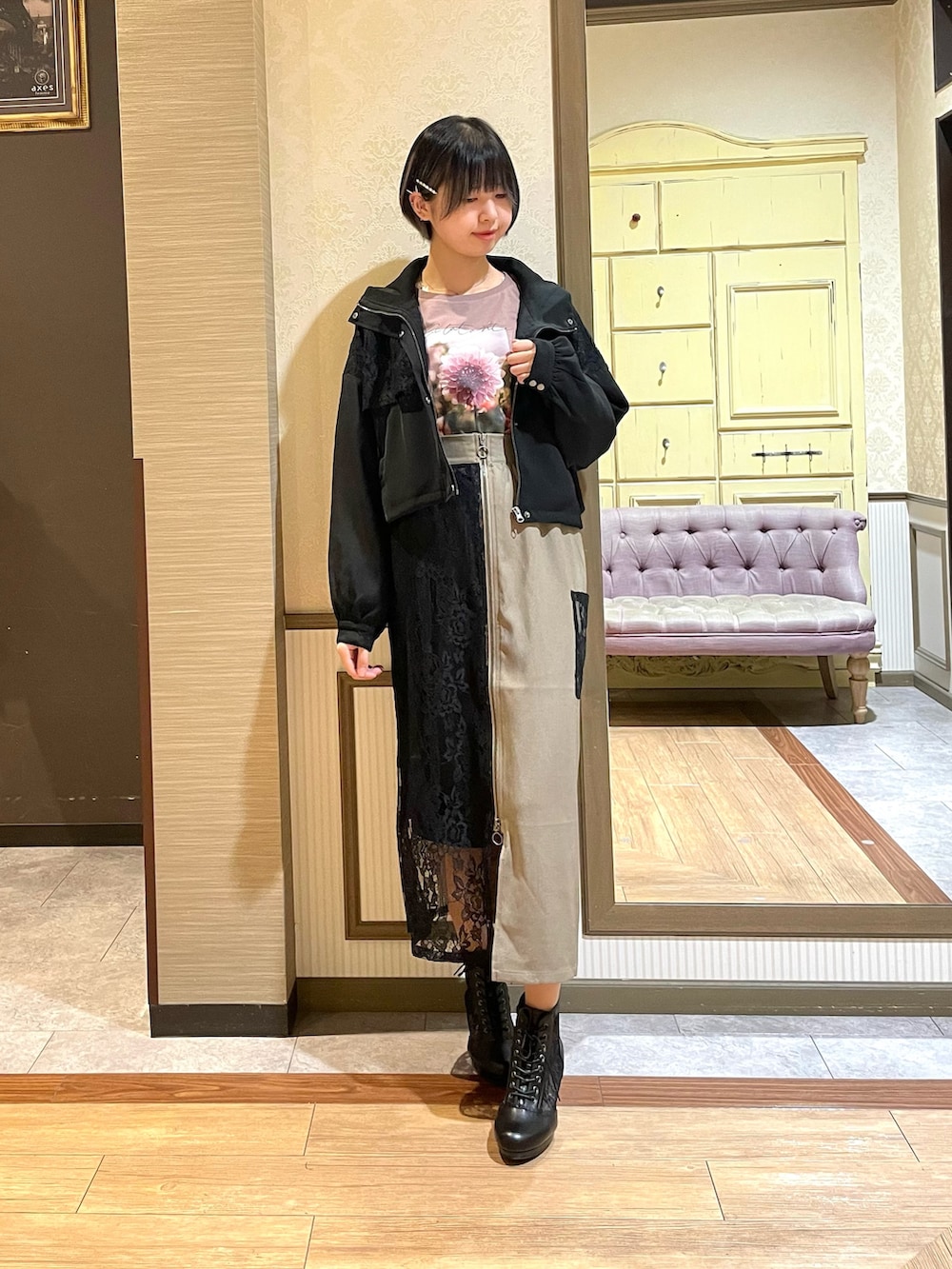 ベージュ系のスカート、ブラウン系のTシャツ/カットソー、ブラック系のブルゾンを着用したレディースの秋コーディネートの2枚目の写真