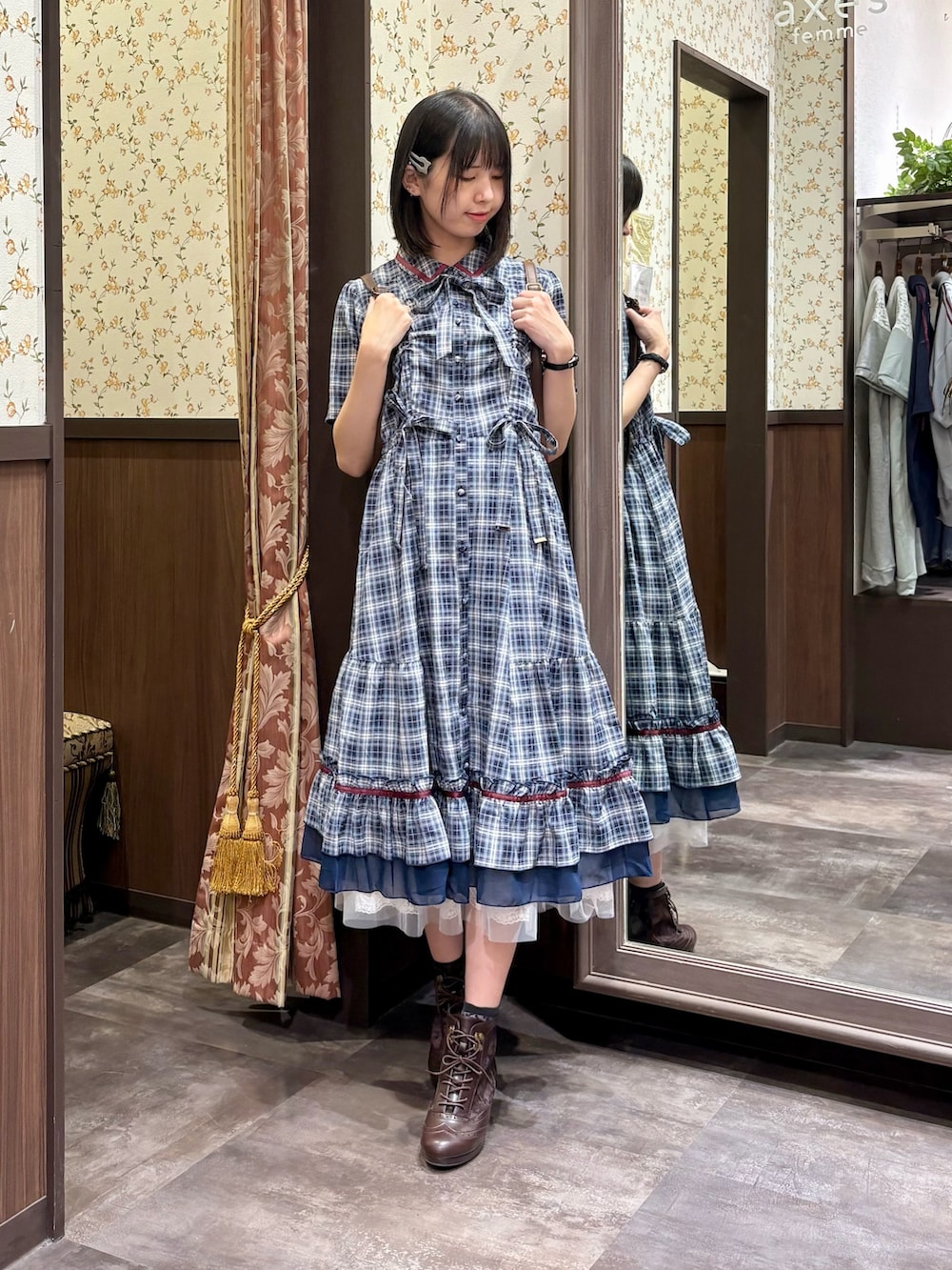 ホワイト系のタンクトップ、ブルー系のワンピース、ブラウン系のボストンバッグを着用したレディースの夏コーディネートの2枚目の写真