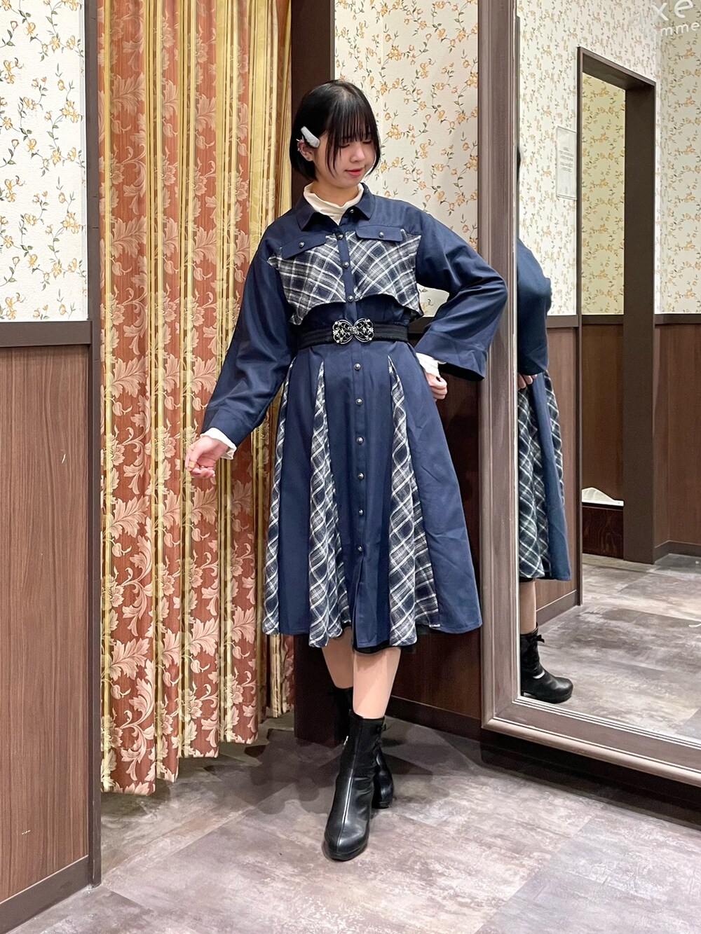 ホワイト系のピーコート、ブルー系のワンピース、ブラック系のブーツを着用したレディースの冬コーディネートの6枚目の写真