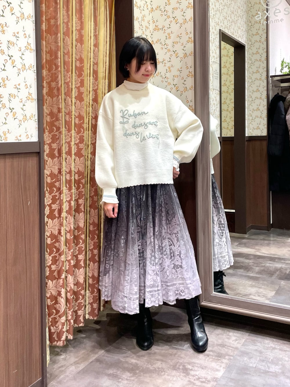 ホワイト系のニット/セーター、ホワイト系のボストンバッグ、ブラウン系のスカートを着用したレディースの冬コーディネートの4枚目の写真