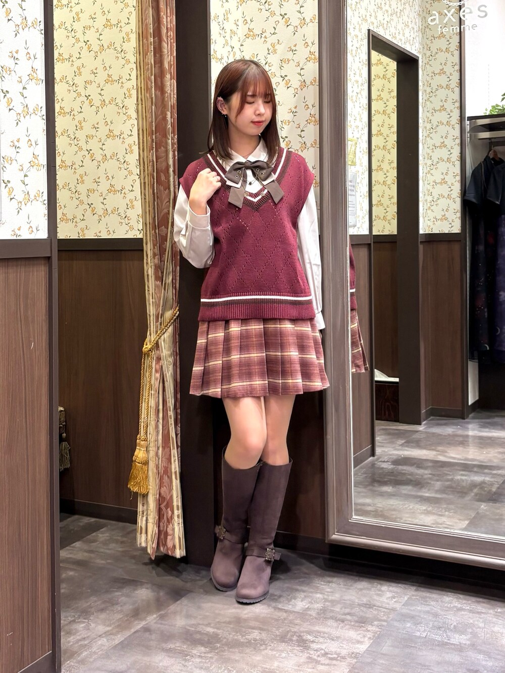 レッド系のベスト、ピンク系のその他パンツ、ブラウン系のブーツを着用したレディースの秋コーディネートの9枚目の写真
