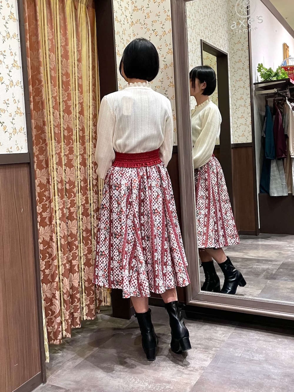 レッド系のスカート、ホワイト系のニット/セーター、ブラウン系のダッフルコートを着用したレディースの冬コーディネートの3枚目の写真