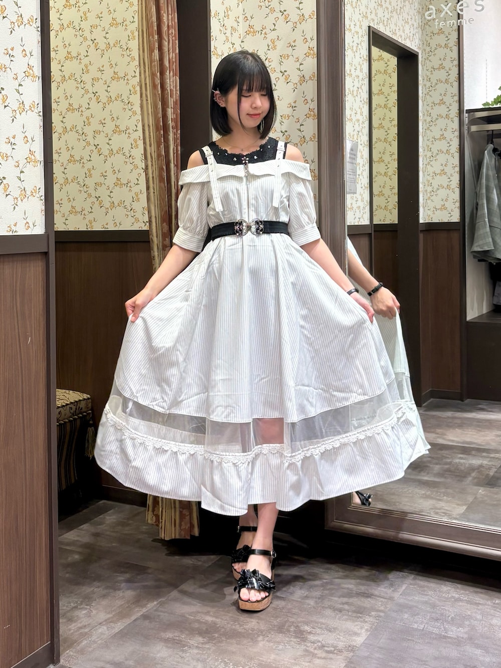 ブラック系のタンクトップ、ホワイト系のワンピース、ブラック系のサンダルを着用したレディースの夏コーディネートの3枚目の写真