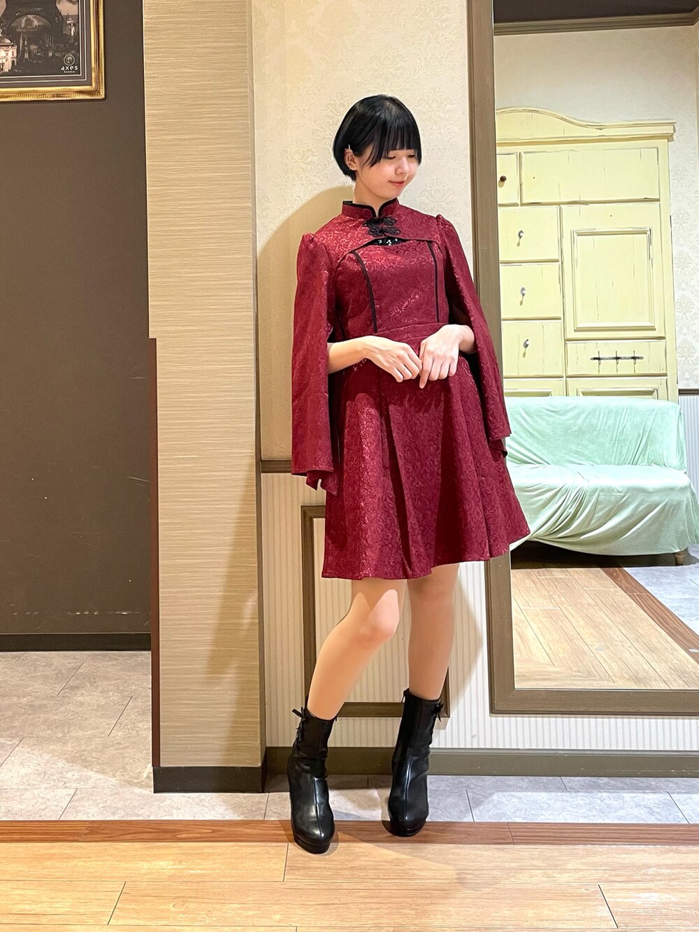 ブラック系のブーツ、レッド系のワンピース、ブラック系のタンクトップを着用したレディースの秋コーディネートの2枚目の写真