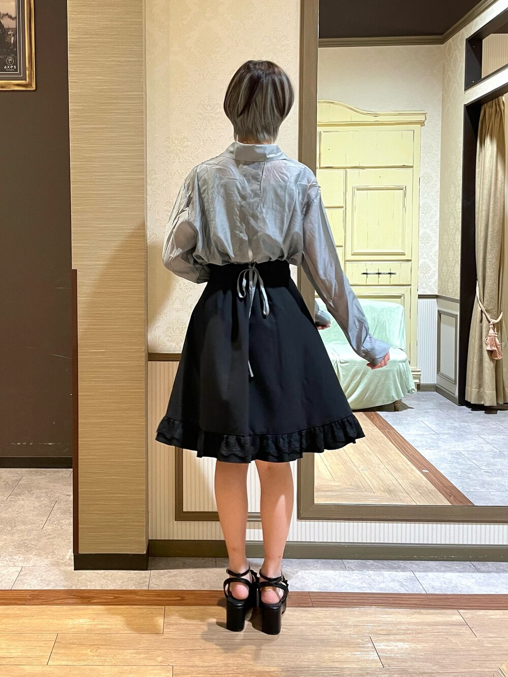 ブラック系のショルダーバッグ、ブラック系のスカート、グリーン系のタンクトップを着用したレディースの夏コーディネートの4枚目の写真