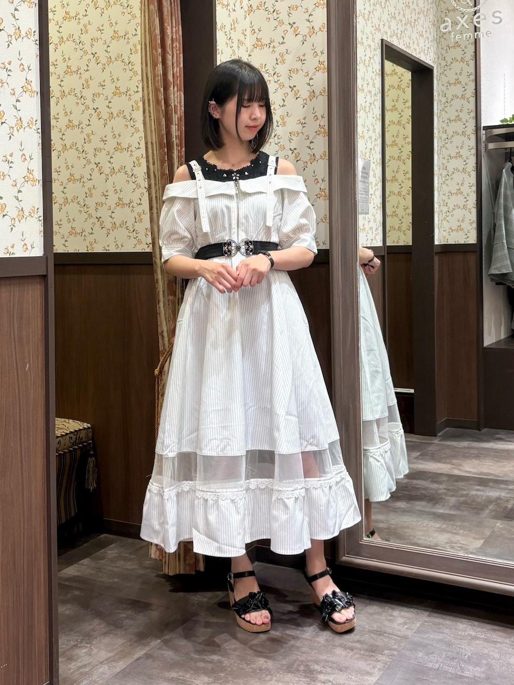ブラック系のタンクトップ、ホワイト系のワンピース、ブラック系のサンダルを着用したレディースの夏コーディネートの2枚目の写真