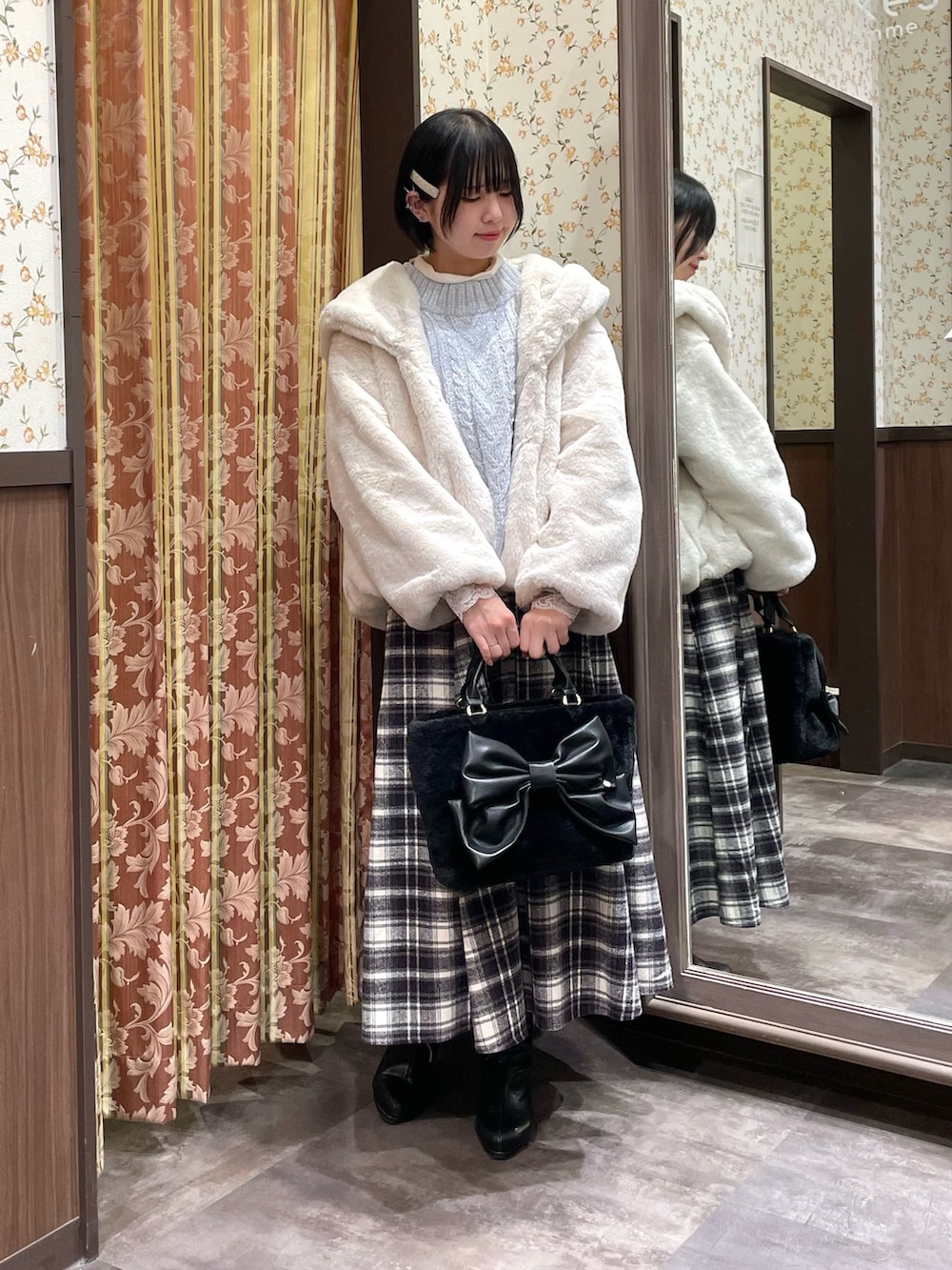 ホワイト系のダッフルコート、ブルー系のニット/セーター、パープル系のスカートを着用したレディースの冬コーディネートの2枚目の写真