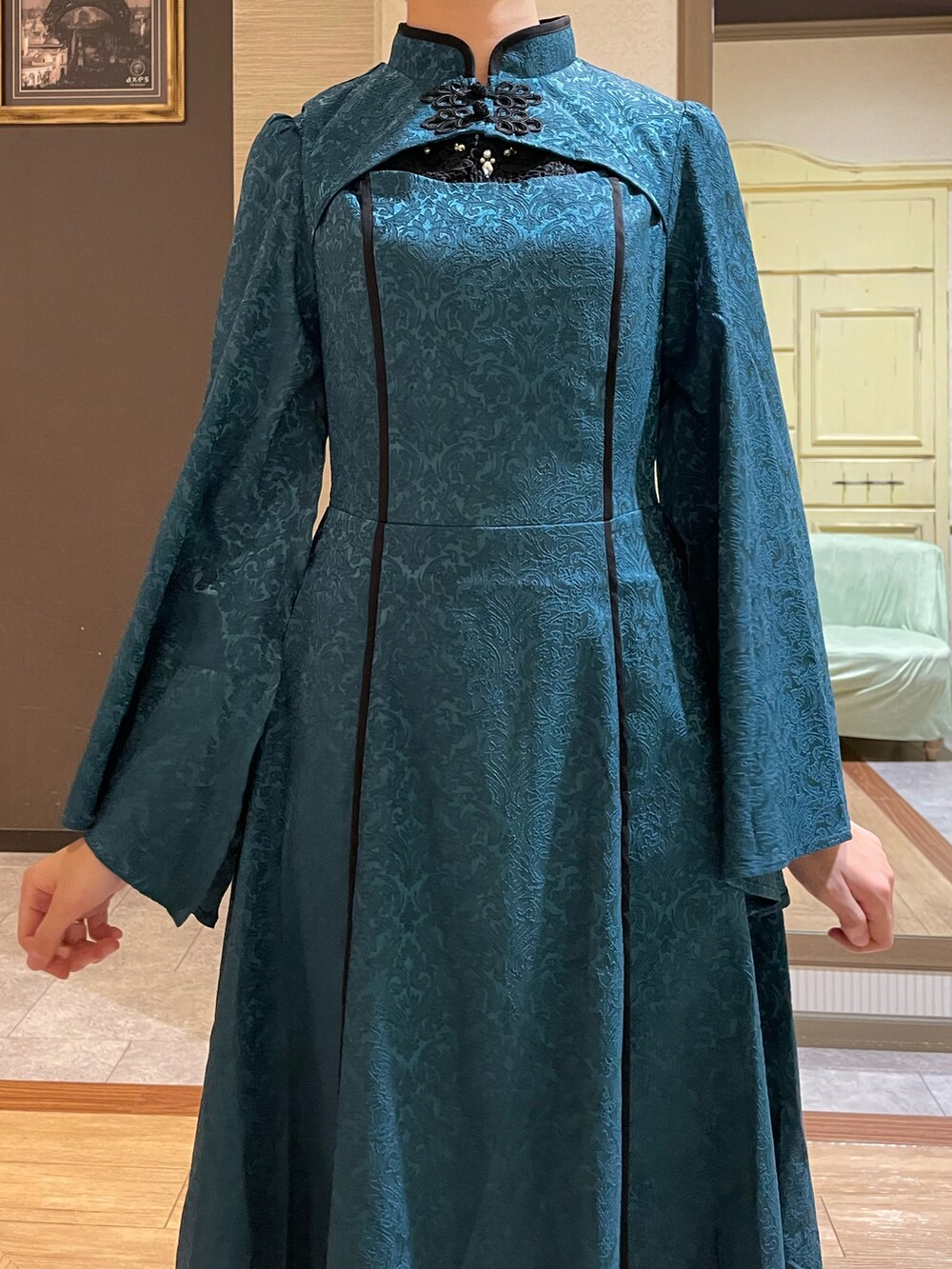 ブラック系のタンクトップ、グリーン系のワンピース、ブラック系のショルダーバッグを着用したレディースの秋コーディネートの5枚目の写真