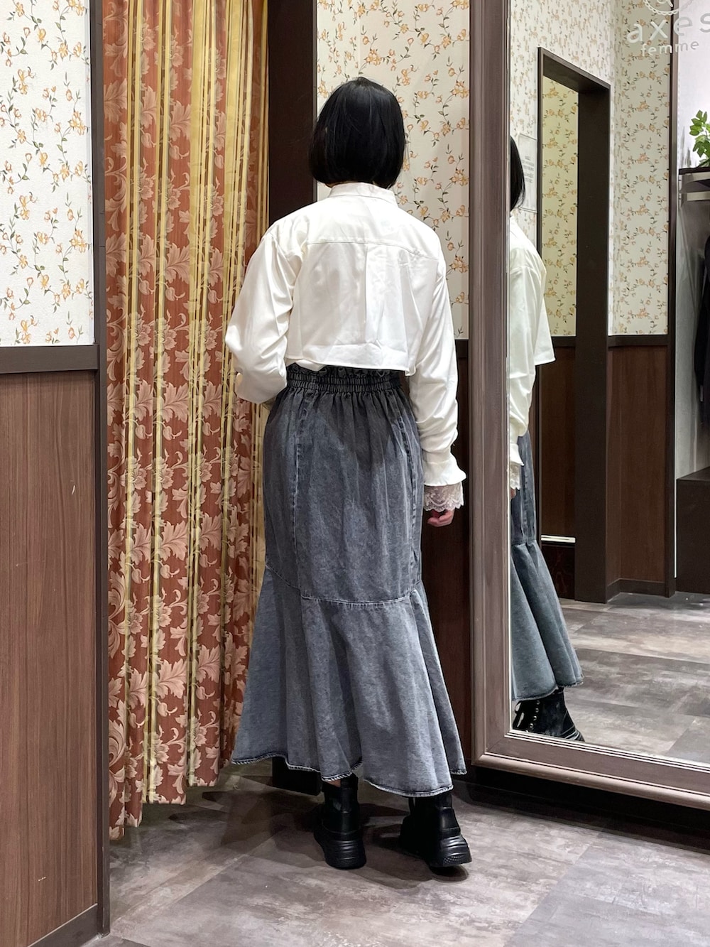 ブラック系のデニムスカート、ブラック系のスニーカー、ブラック系のカーディガン/ボレロを着用したレディースの冬コーディネートの3枚目の写真