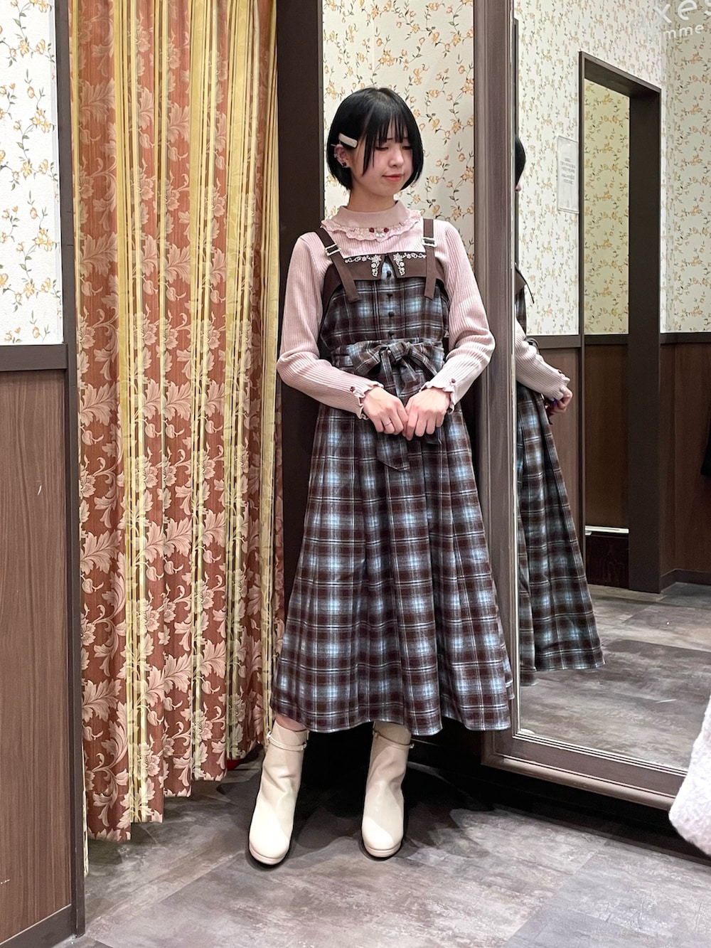 ホワイト系のカーディガン/ボレロ、ブラウン系のジャンパースカート、ピンク系のニット/セーターを着用したレディースの冬コーディネートの9枚目の写真