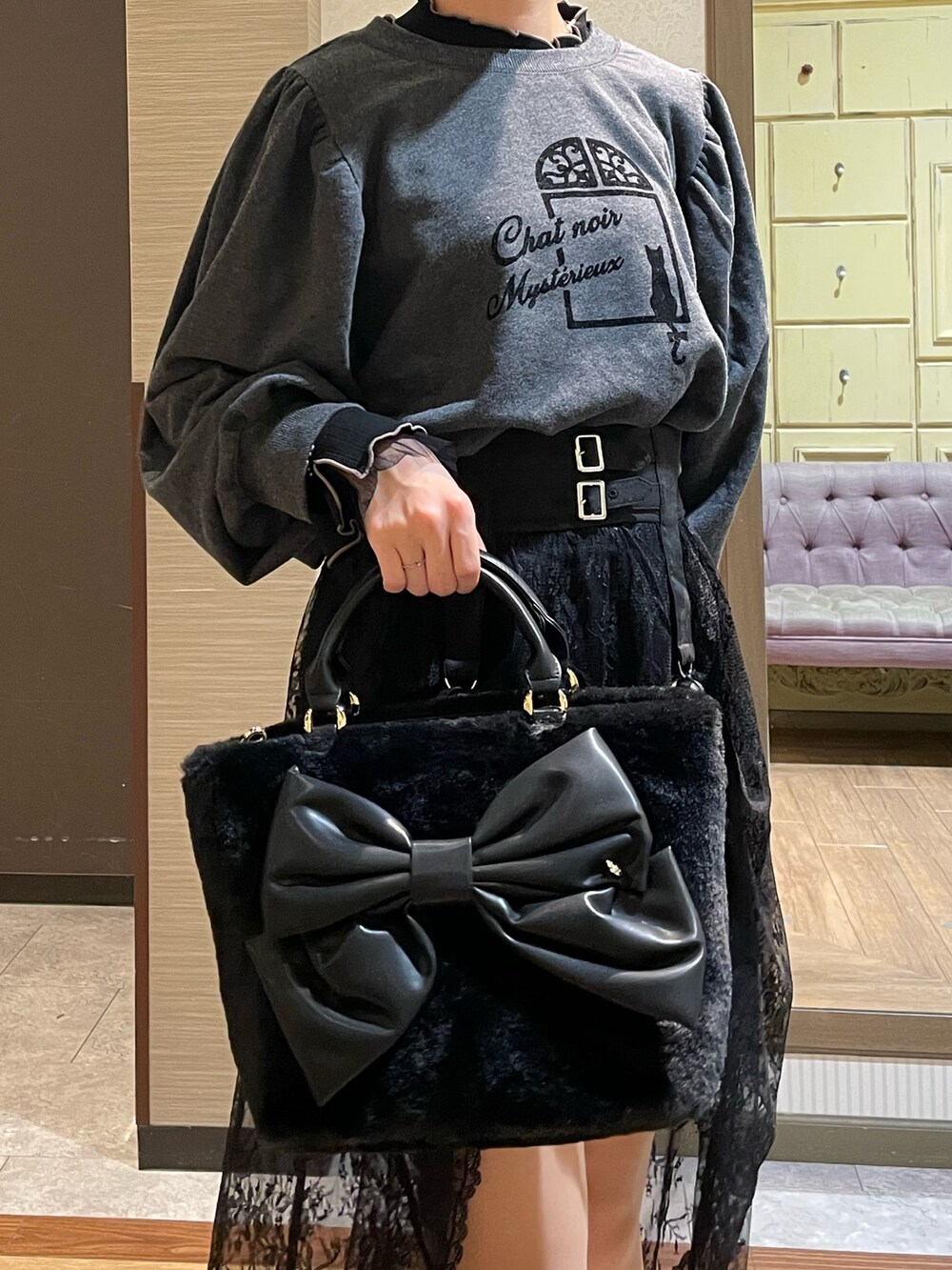 ブラック系のスカート、ブラック系のブーツ、ブラック系のショルダーバッグを着用したレディースの秋コーディネートの5枚目の写真