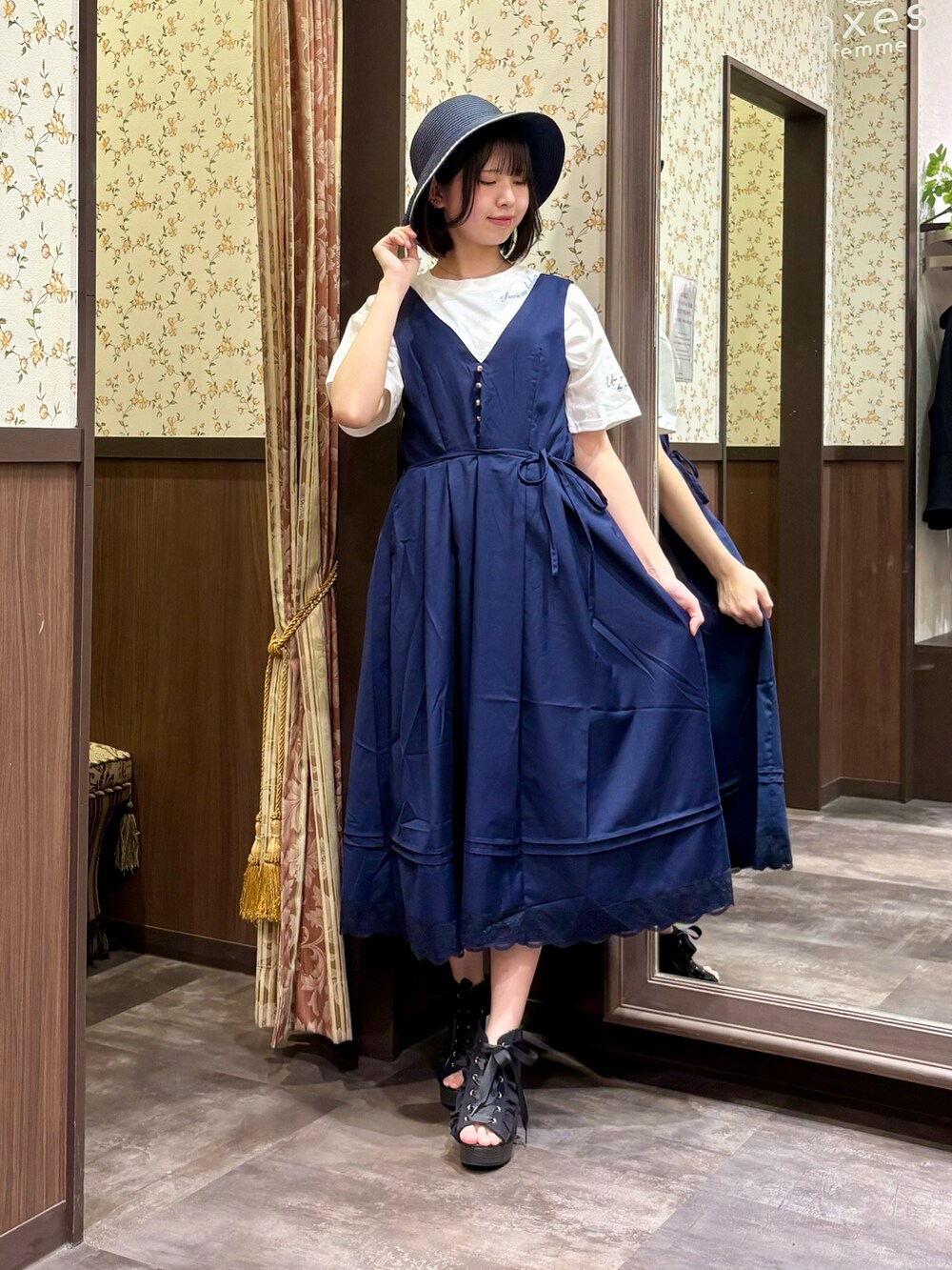 ホワイト系のTシャツ/カットソー、ブルー系のタンクトップ、ブルー系のジャンパースカートを着用したレディースの春コーディネートの3枚目の写真