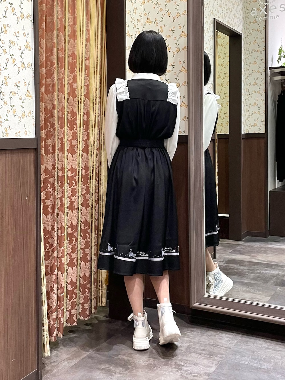 ホワイト系のスニーカー、ブラック系のワンピース、ブラック系のショルダーバッグを着用したレディースの春コーディネートの3枚目の写真