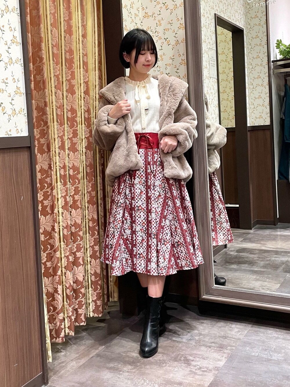 レッド系のスカート、ホワイト系のニット/セーター、ブラウン系のダッフルコートを着用したレディースの冬コーディネートの5枚目の写真