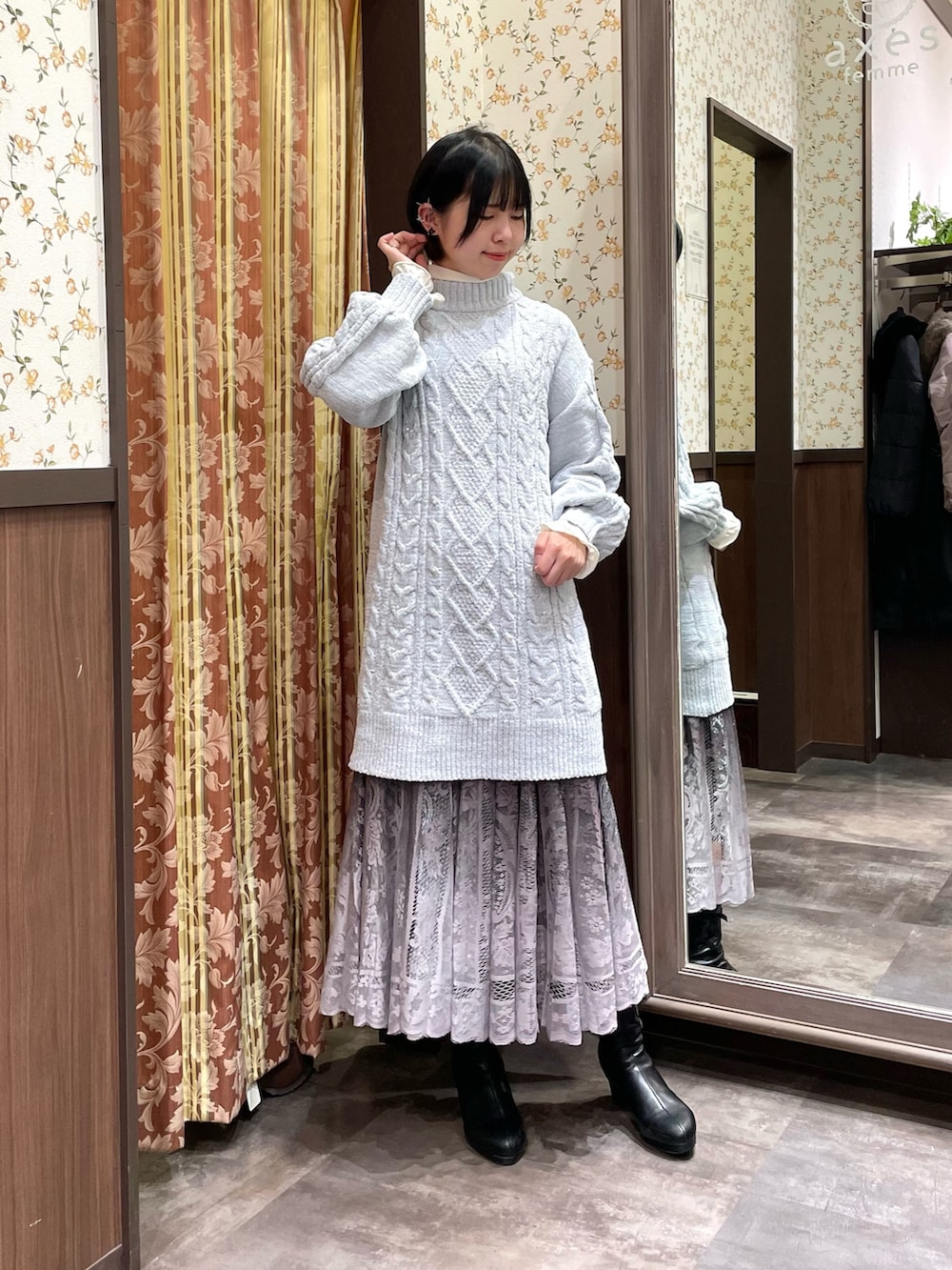 ブラック系のブーツ、ブラウン系のスカート、ホワイト系のボストンバッグを着用したレディースの冬コーディネートの5枚目の写真