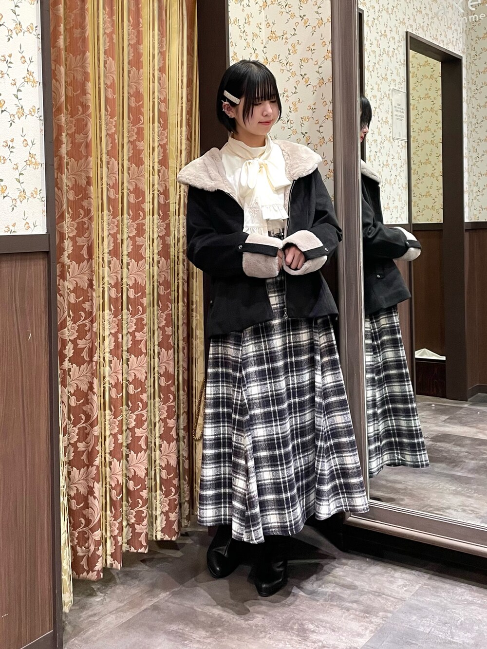 パープル系のスカート、ホワイト系のシャツ/ブラウス、ブラック系のブーツを着用したレディースの冬コーディネートの5枚目の写真