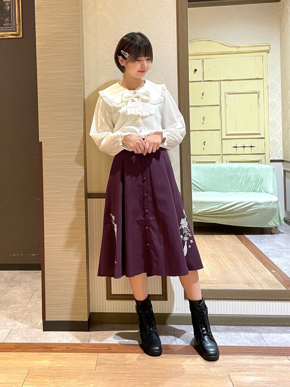 レッド系のスカート、ブラック系のブーツ、ブラック系のショルダーバッグを着用したレディースの秋コーディネートの4枚目の写真