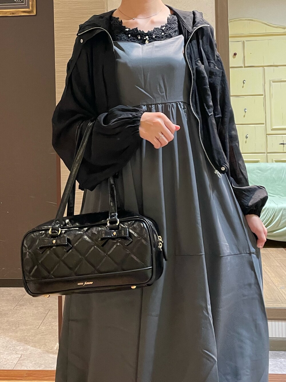 ブラック系のブルゾン、ブラック系のタンクトップ、グレー系のジャンパースカートを着用したレディースの秋コーディネートの3枚目の写真