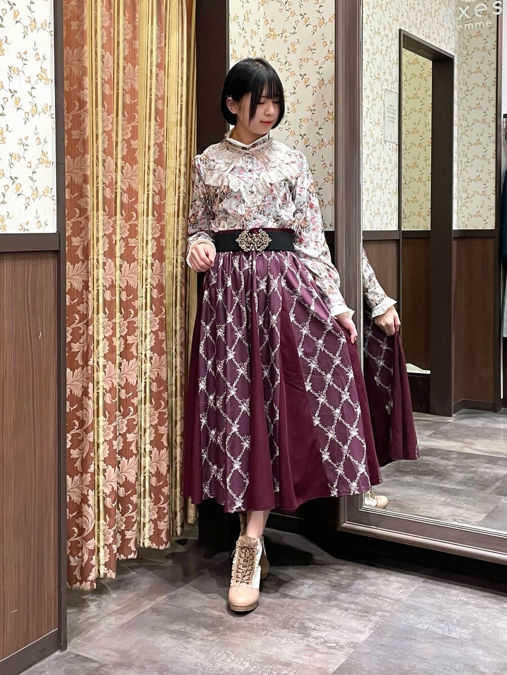 ホワイト系のカーディガン/ボレロ、グリーン系のシャツ/ブラウス、レッド系のスカートを着用したレディースの冬コーディネートの6枚目の写真