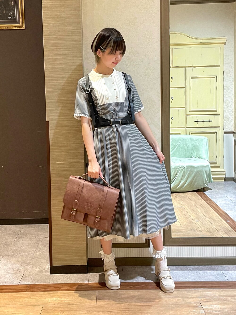 ホワイト系のタンクトップ、ホワイト系のローファー、ブラウン系のショルダーバッグを着用したレディースの夏コーディネートの2枚目の写真