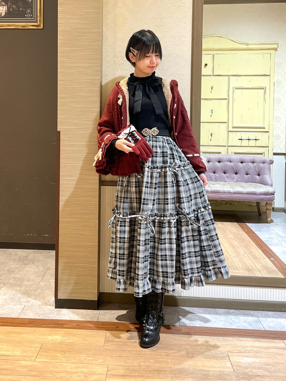 ブラック系のニット/セーター、レッド系のポンチョ、ブラック系のトートバッグを着用したレディースの秋コーディネートの2枚目の写真