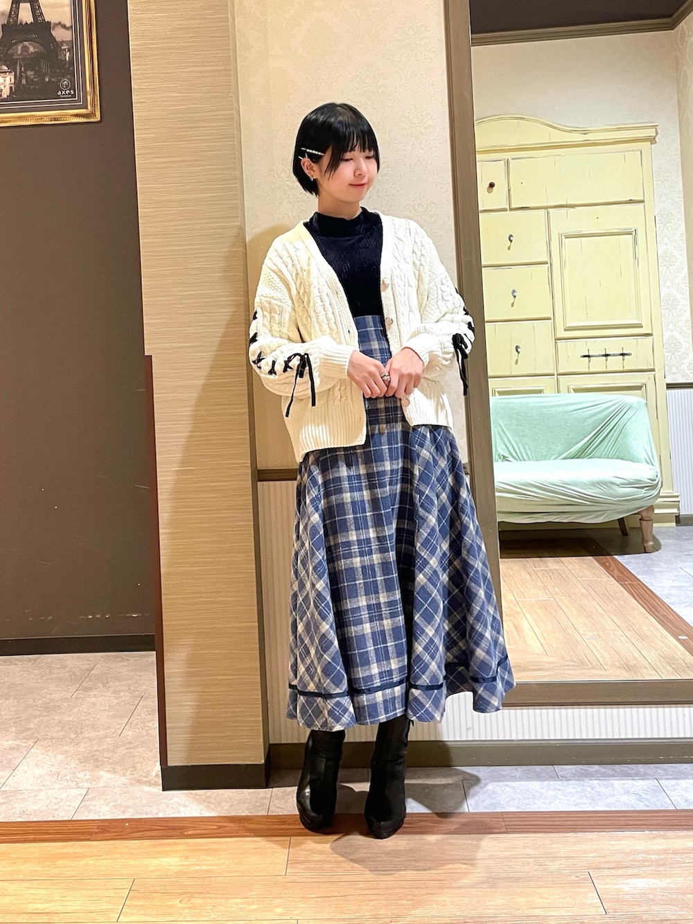 ブラック系のブーツ、ホワイト系のカーディガン/ボレロ、ブルー系のスカートを着用したレディースの秋コーディネートの4枚目の写真
